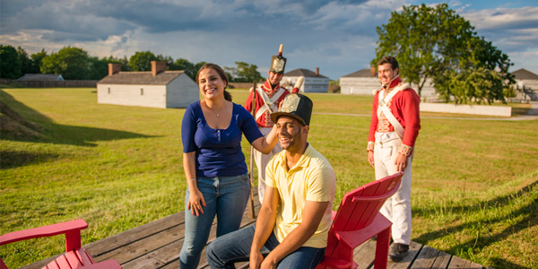 Un jeune couple s’amusant à essayer un shako de soldat, lieu historique national du Fort-George.