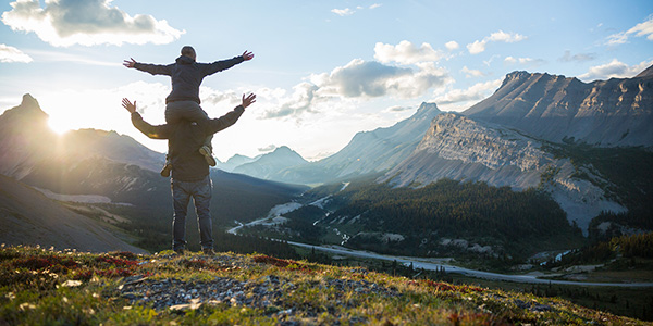 Two visitors pose with one on the other’s shoulder at the view point of Parker’s Ridge in Jasper National Park.