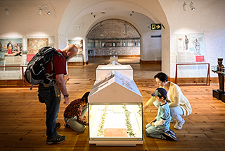 A family of 4 enjoying the Passages, Experiences of this Island exhibition held in the barracks of the fort