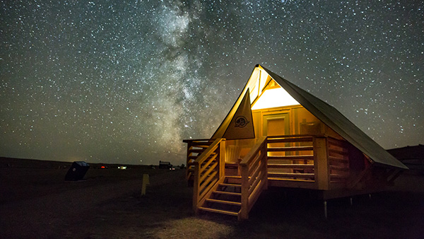 Une tente oTENTik dans la réserve de ciel étoilé du parc national des Prairies avec la Voie lactée en arrière-plan.
