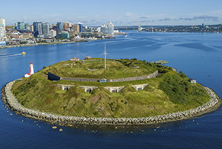 Aerial image of Georges Island showing the lower battery with four arched stone chambers and the Halifax waterfront in background.