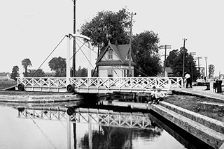 Une photo d’époque d’un pont au-dessus du canal de Chambly qui roule pour laisser passer les bateaux.